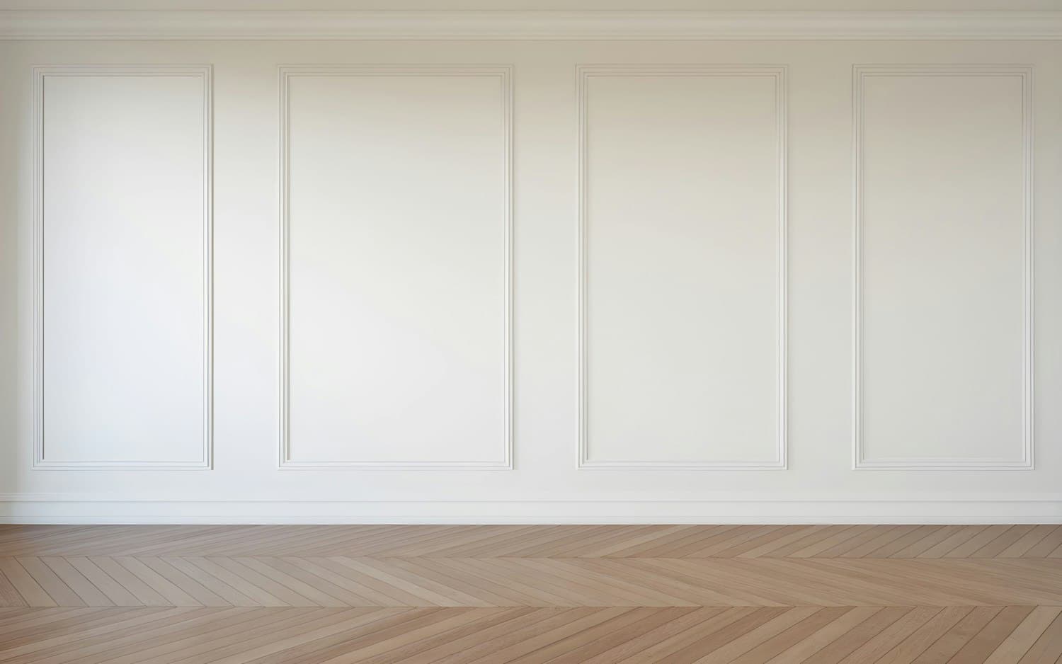 Mur à moulures et parquet à chevrons dans une lumière douce